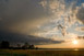 Tiefstehende Sonne ber dem Starnberger See, links daneben das Gewitter