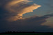 Von Westsüdwest herannahendes Gewitter in der Abenddämmerung - ein hochfliegendes Flugzeug macht einen weiten Bogen um die Gewitterzelle